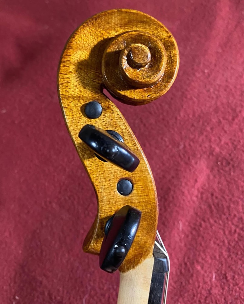 Violino e arco dispostos na bancada do luthier.