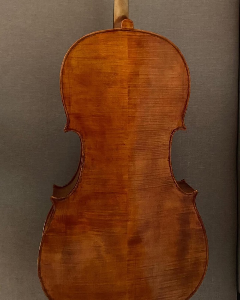 Violoncelo em progresso sobre cavaletes na oficina.