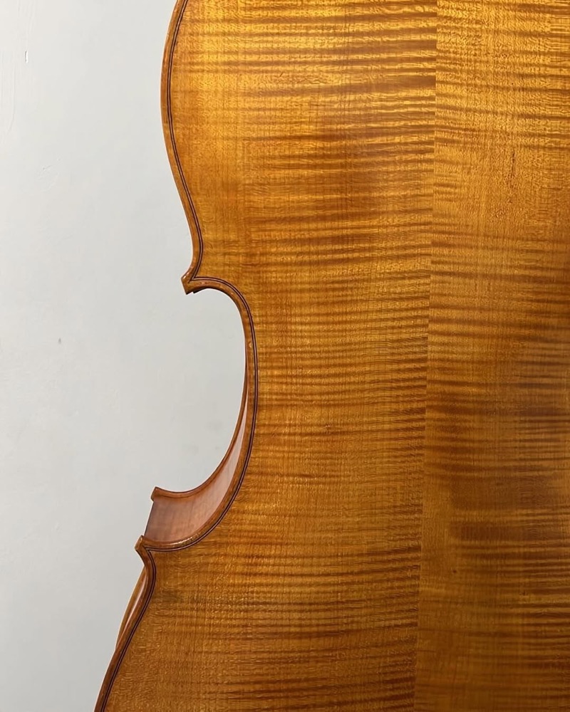 Violoncelo na bancada com materiais de oficina ao redor.